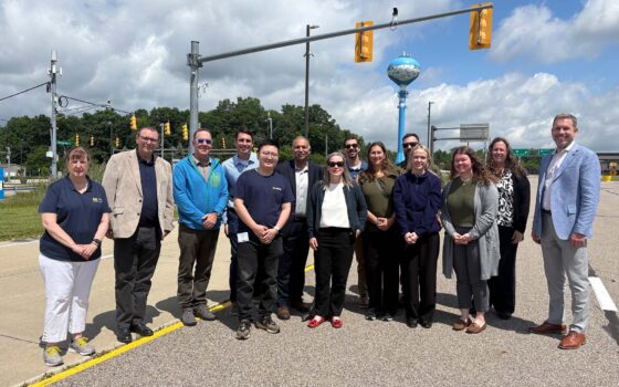 University of Michigan and Federal Highway Administration leadership stand together at the Mcity Test Facility