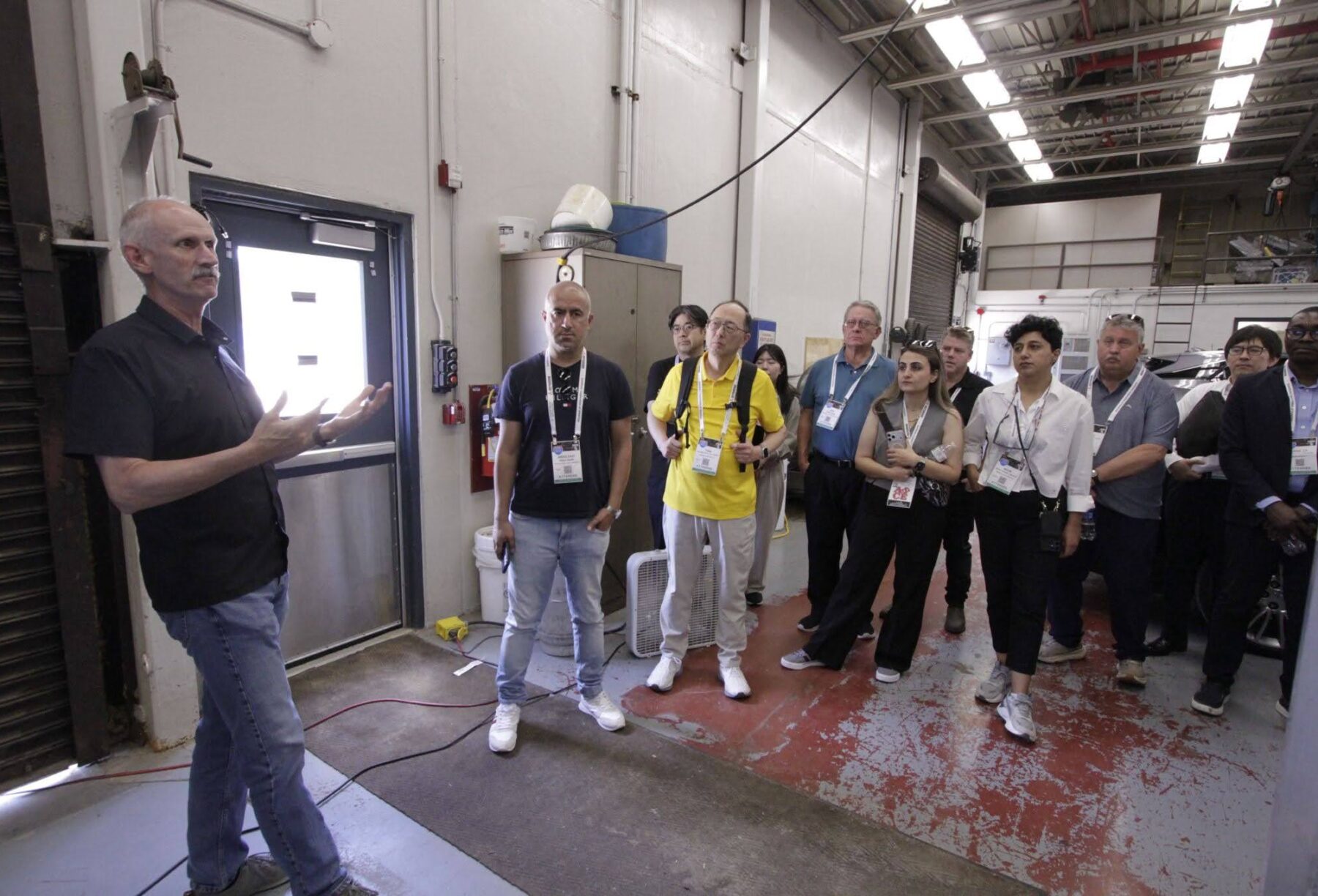 Mark Gilbert stands in a high bay with attendees from the ASCE conference